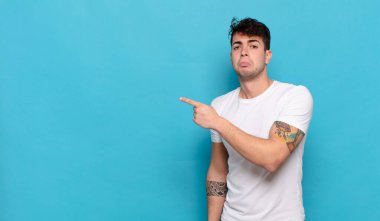 Mavi arka planda genç yakışıklı adam