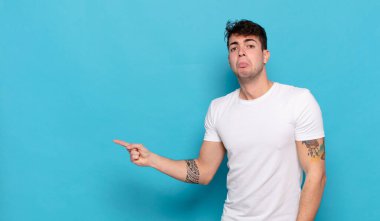 Mavi arka planda genç yakışıklı adam