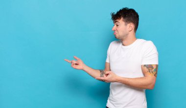 Mavi arka planda genç yakışıklı adam