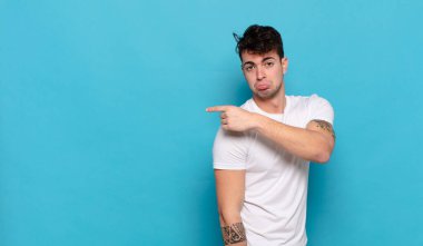 Mavi arka planda genç yakışıklı adam