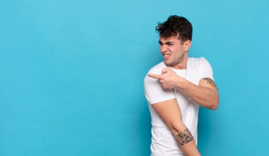 Mavi arka planda genç yakışıklı adam