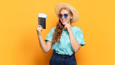 Mutlu, kendinden emin bir ifadeyle gülümsüyor, elleri çenesinde, merak ediyor ve yan tarafa bakıyor.