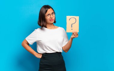 Soru işareti konsepti olan genç ve güzel bir kadın.