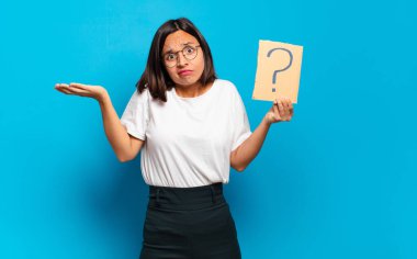 Soru işareti konsepti olan genç ve güzel bir kadın.