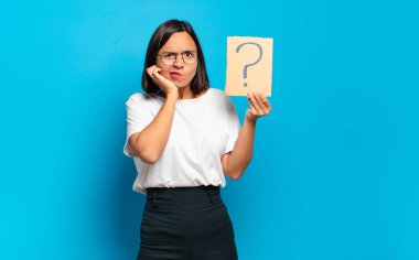 Soru işareti konsepti olan genç ve güzel bir kadın.