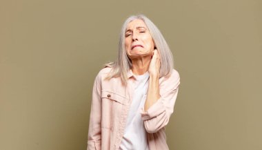 Son sınıf öğrencisi stresli, hayal kırıklığına uğramış ve yorgun hissediyordu. Endişeli ve sorunlu bir bakışla boynunu ovuyordu.