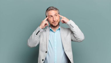 Yetişkin iş adamı kafası karışık ya da şüpheci hissediyor, bir fikre odaklanıyor, çok düşünüyor, kenarda boşluğu kopyalamak istiyor.