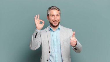 Yetişkin iş adamı kendini mutlu, şaşkın, tatmin olmuş ve şaşırmış hissediyor.