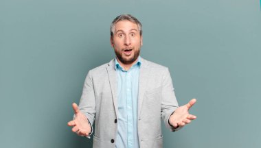 Yetişkin iş adamı ağzı açık ve şaşırmış, şok olmuş ve hayrete düşmüş.