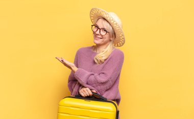 Sarışın kadın mutlu bir şekilde gülümsüyor, mutlu hissediyor ve fotokopi alanında avucunun içinde bir konsept gösteriyor.