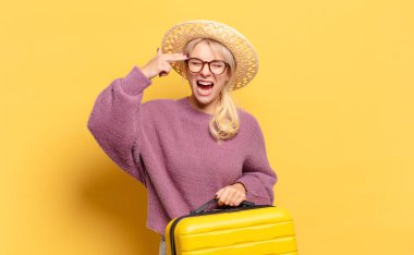 Sarışın kadın mutsuz ve stresli görünüyor, intihar jesti elle silah işareti yapıyor, kafasını işaret ediyor.