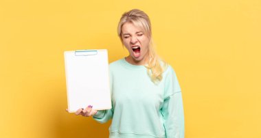 Sarışın kadın agresif bir şekilde bağırıyor, çok kızgın, sinirli, öfkeli ya da sinirli görünüyor.