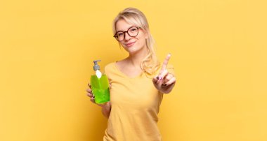 Sarışın kadın gururla gülümsüyor ve gururla bir numaralı pozunu veriyor, kendini lider gibi hissediyor.