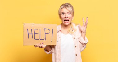 Sarışın kadın ellerini havaya kaldırıp bağırıyor. Öfkeli, sinirli, stresli ve üzgün.