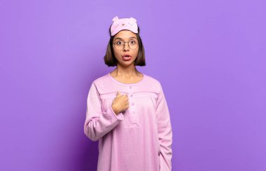 Şok olmuş ve ağzı açık, kendini işaret eden genç İspanyol bir kadın.