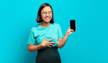 Genç İspanyol kadın komik bir şakaya yüksek sesle gülüyor, mutlu ve neşeli hissediyor, eğleniyor.