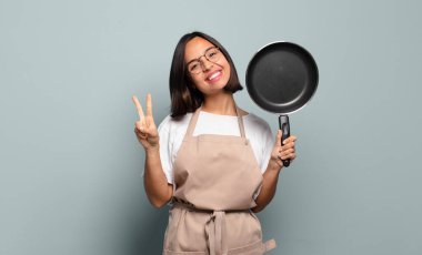 Genç İspanyol kadın gülümsüyor ve mutlu görünüyor, kaygısız ve pozitif, zafer ya da barışı simgeliyor.