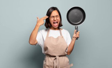 Genç İspanyol kadın mutsuz ve stresli görünüyor, intihar jesti elle silah işareti yapıyor, kafasını işaret ediyor.