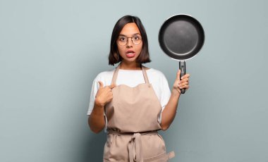 Şok olmuş ve ağzı açık, kendini işaret eden genç İspanyol bir kadın.