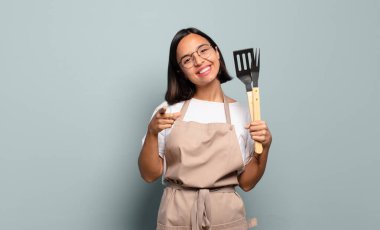 Genç İspanyol kadın kameraya tatmin olmuş, kendinden emin, dost canlısı bir gülümsemeyle bakıyor ve seni seçiyor.