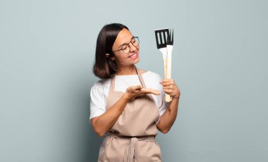 Genç İspanyol kadın neşeyle gülümsüyor, mutlu hissediyor ve fotokopi uzayda bir konsept gösteriyor.