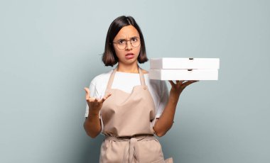 Genç İspanyol kadın aşırı derecede şaşırmış, şaşırmış, endişeli ve paniklemiş, stresli ve dehşete kapılmış görünüyor.