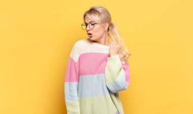 sarışın kadın stresli, endişeli, yorgun ve hayal kırıklığına uğramış, gömleğini çekiştiren, sıkıntılı görünen