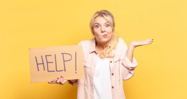 Sarışın kadın şaşkın ve şaşkın hissediyor, şüpheci, farklı seçenekleri tartıyor veya komik bir ifadeyle seçiyor.