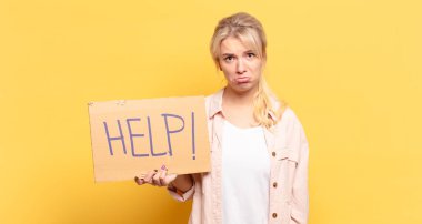 Sarışın kadın üzgün ve mızmızlanıyor, mutsuz bir bakışla, negatif ve hayal kırıklığına uğramış bir tavırla ağlıyor.