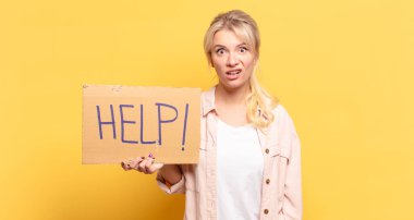blonde woman feeling puzzled and confused, with a dumb, stunned expression looking at something unexpected