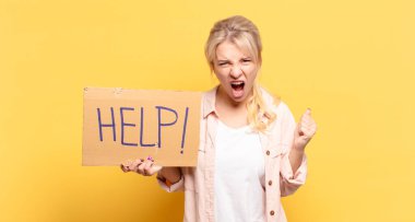 Sarışın kadın öfkeli bir ifadeyle ya da yumruklarıyla başarıyı kutlarken agresif bir şekilde bağırıyor.