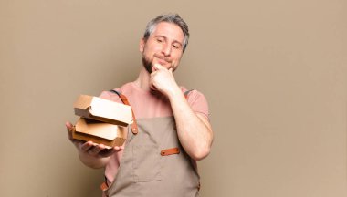 Hamburgerli orta yaşlı aşçı. barbekü konsepti