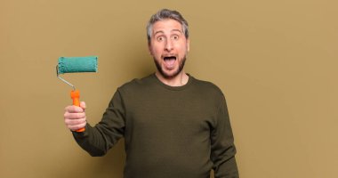 Patenli boya dekorasyonu konsepti olan orta yaşlı bir adam.