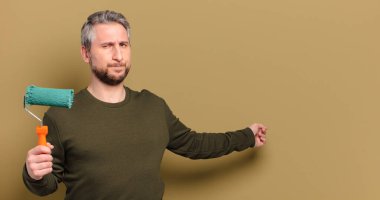 Patenli boya dekorasyonu konsepti olan orta yaşlı bir adam.