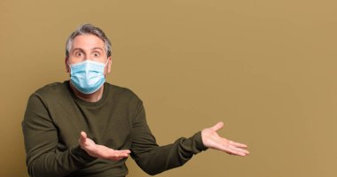 Koruyucu maskeli orta yaşlı bir adam.