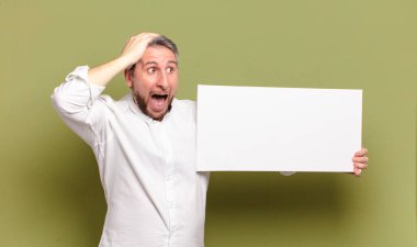 Boş afişi olan orta yaşlı bir adam.