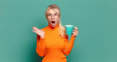 Kahve ya da çay fincanı olan sarışın güzel bir kadın.