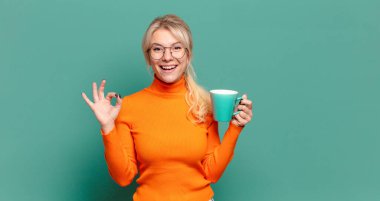 Kahve ya da çay fincanı olan sarışın güzel bir kadın.