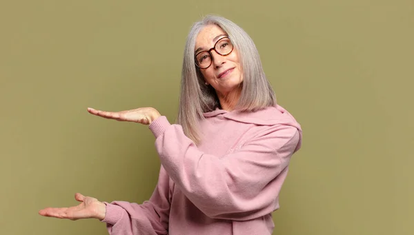 Senior Vrouw Die Een Object Met Beide Handen Aan Zijkant — Stockfoto