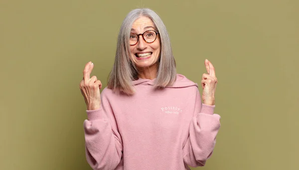 Senior Woman Smiling Anxiously Crossing Both Fingers Feeling Worried Wishing — Stock Photo, Image