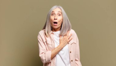 Son sınıftaki kadın şok olmuş ve şaşırmış hissediyor, gülümsüyor, el ele tutuşuyor, o olmaktan mutlu ya da minnettarlık gösteriyor.