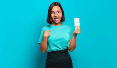 Genç İspanyol kadın mutlu, şaşkın ve gururlu hissediyor. Heyecanlı ve şaşkın bir bakışla kendini işaret ediyor.