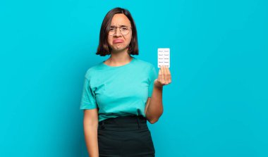 Genç İspanyol kadın üzgün ve mızmızlanıyor, mutsuz bir bakışla, negatif ve hayal kırıklığına uğramış bir tavırla ağlıyor.