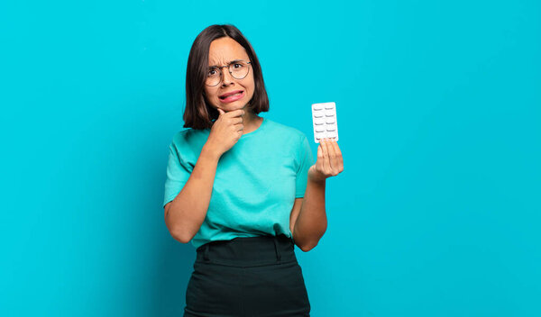 молодая латиноамериканка с открытым ртом и широко открытыми глазами и рукой на подбородке, чувствующая себя неприятно шокированной, говоря что или вау