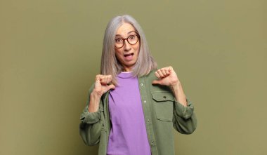 Son sınıf öğrencisi, mutlu, şaşkın ve gururlu. Heyecanlı ve şaşkın bir bakışla kendini işaret ediyor.