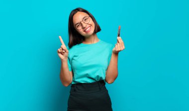 Genç İspanyol kadın gülümsüyor ve arkadaş canlısı görünüyor, bir numara veya ilk eli önde, geriye doğru sayıyor.