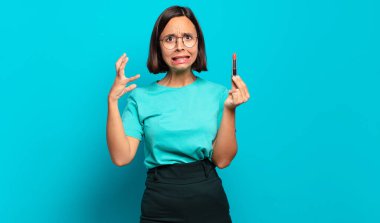 Genç İspanyol kadın ellerini havaya kaldırıp bağırıyor. Öfkeli, sinirli, stresli ve üzgün.