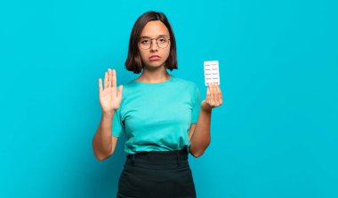 Genç İspanyol kadın ciddi, sert, hoşnutsuz ve kızgın görünüyor. Avuç içinin açık olması jesti durduruyor.