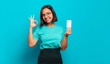 Genç İspanyol kadın kendini mutlu, rahat ve tatmin olmuş hissediyor. Onayını iyi bir hareketle gösteriyor. Gülümsüyor.