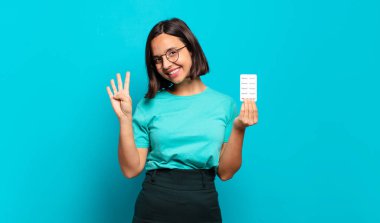 Genç İspanyol kadın gülümsüyor ve arkadaş canlısı görünüyor. Elleri önde, geriye doğru sayıyor.